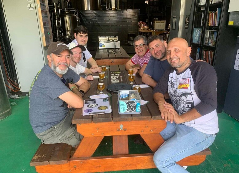 A group of people sitting at a wooden table with beer glasses and a clipboard. 4