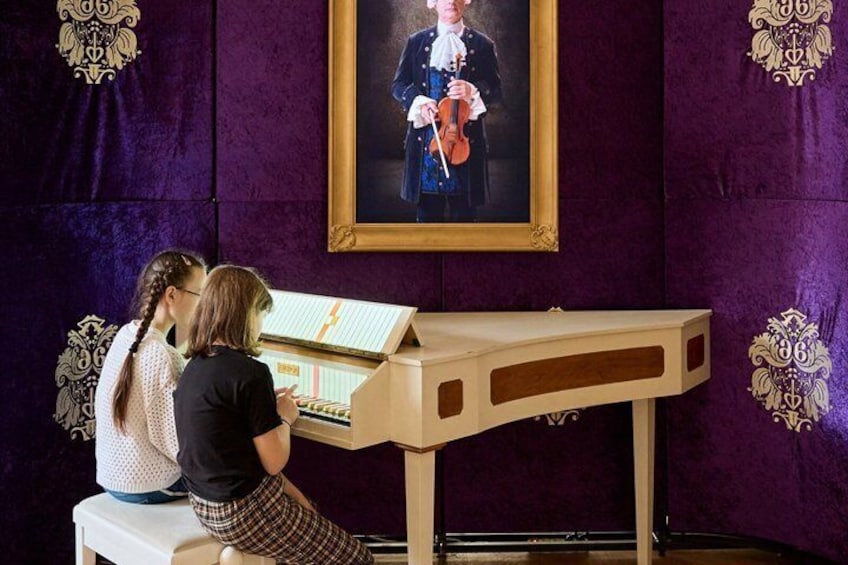Two people playing a stringed instrument at a piano. 3