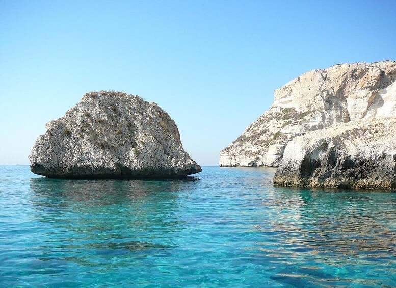A clear blue sea with two rocky formations. 2