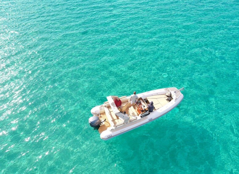 A small motorboat on clear turquoise water. 5