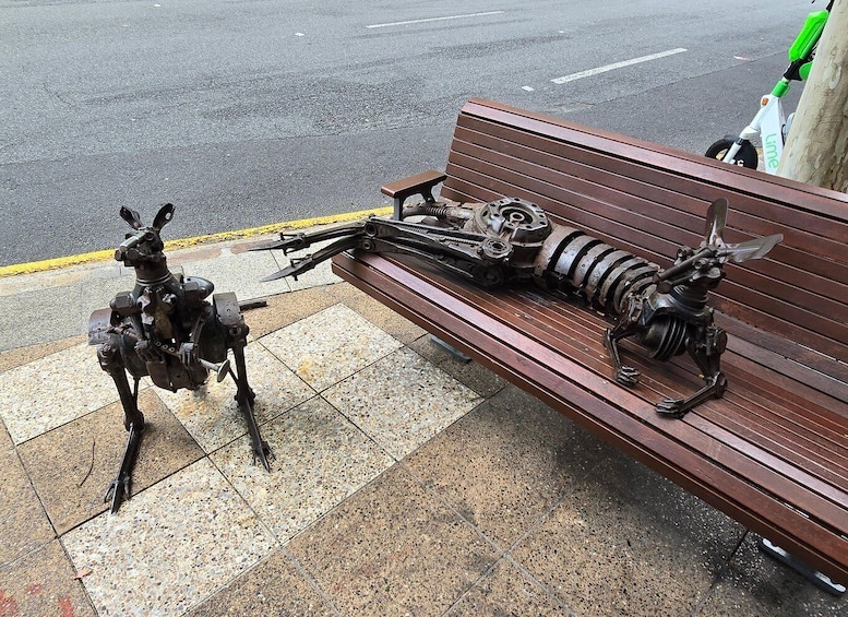 A bench with a sculpture of a mechanical structure on it. 4