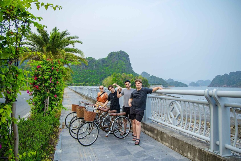 A group of people on a bridge with bicycles, surrounded by greenery and a body of water. 5