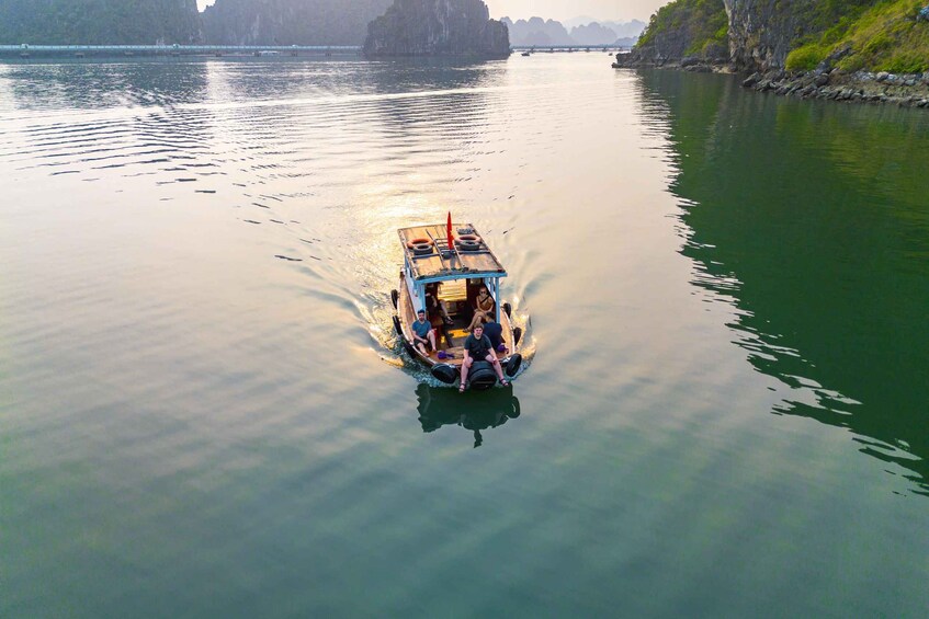 A boat with passengers on a calm river surrounded by rocky cliffs. 1