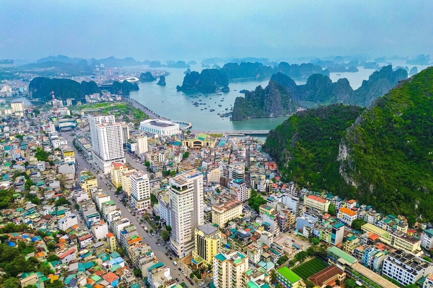 A coastal city with dense urban development, a river, and surrounding mountainous terrain. 2
