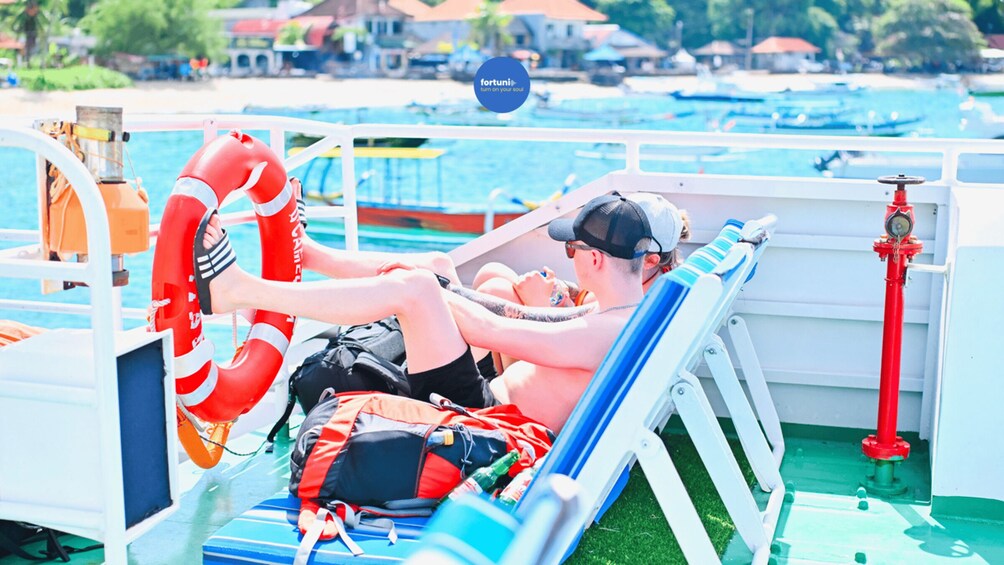A person sunbathing on a boat with lifebuoys and a water pump. 4