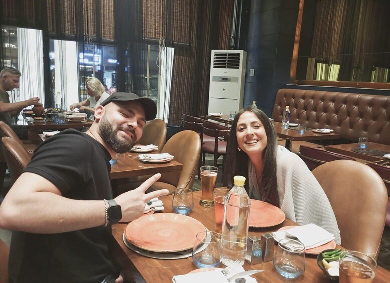 A restaurant interior with leather booths, a dining table with plates, glasses, and a water bottle. 5