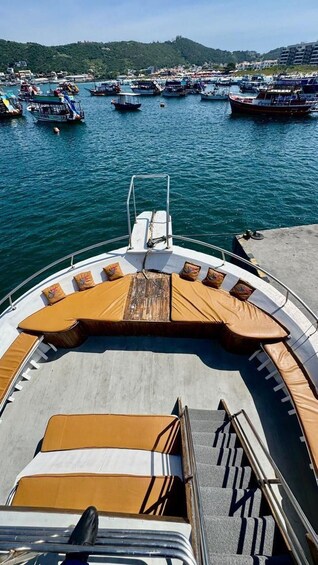 A boat with a sun lounge and a view of a marina with other boats. 5