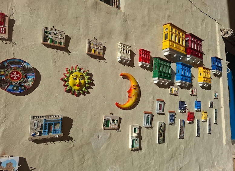 A wall with colorful miniature buildings, a sun, and a crescent moon. 2