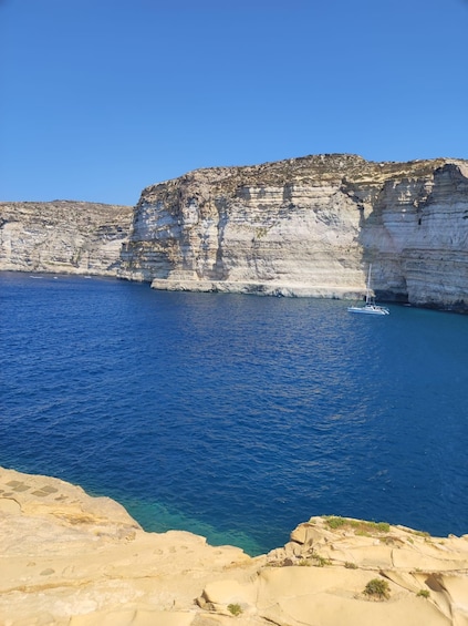 A coastal cliff with a boat in the water. 5