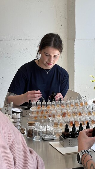 A person at a table with various small containers, likely for samples or products. 5