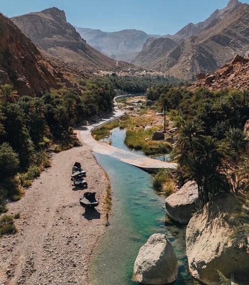 A river winding through a mountainous landscape with clear water, surrounded by rocky terrain and sparse vegetation. 2