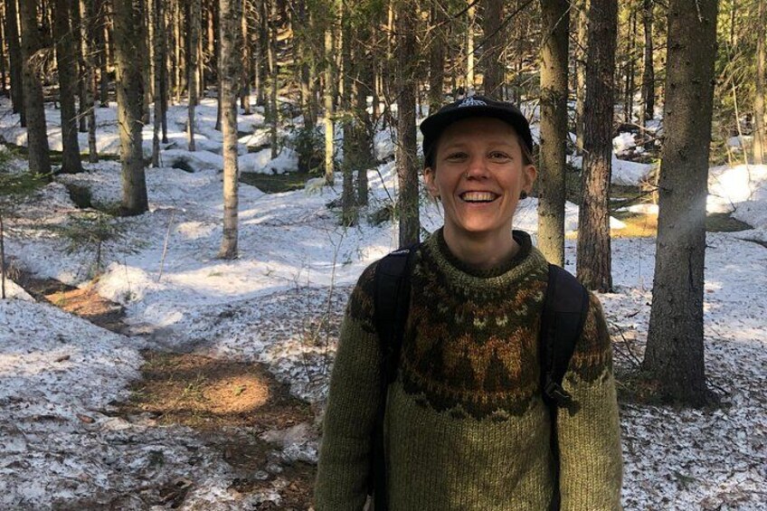 A person in a forest with snow on the ground and trees. 3