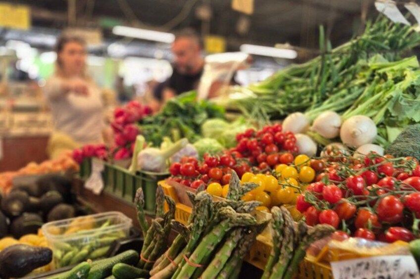 Een markt met diverse groenten, zoals tomaten, asperges en bladgroenten. 1