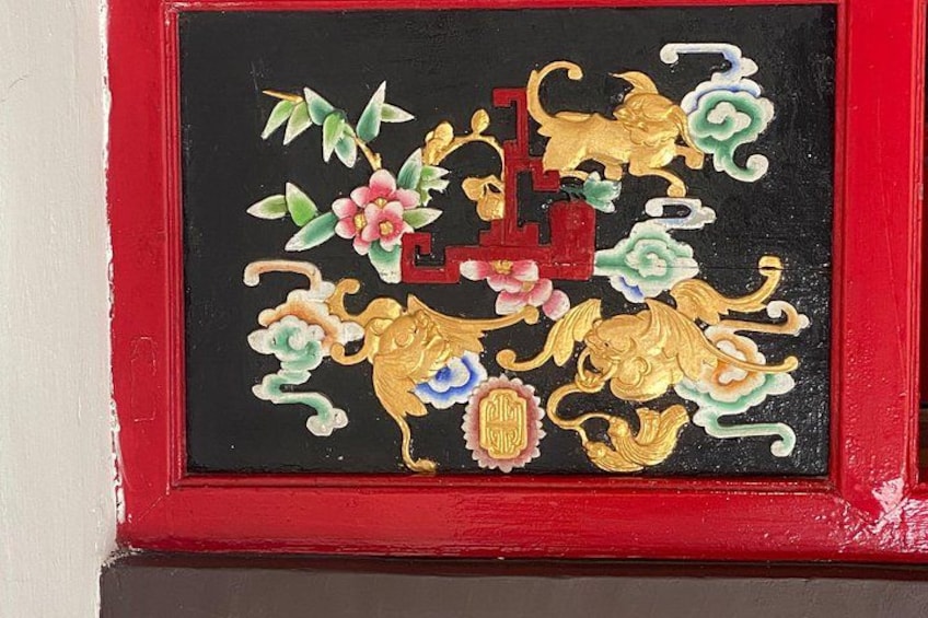 A traditional Chinese painting with red and gold colors, featuring a lion, flowers, and Chinese characters. 4