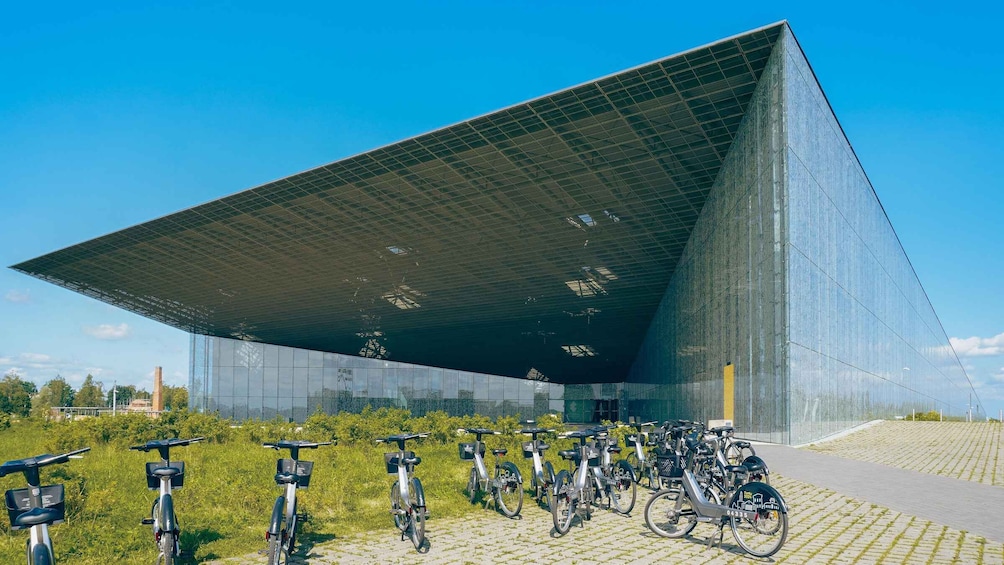 A modern building with a large glass facade and a sloped roof. 2