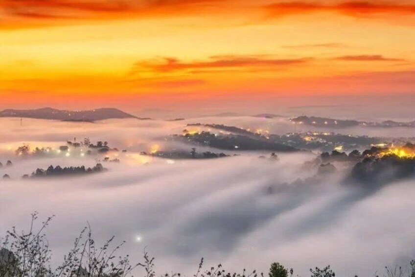 Un amanecer sobre un paisaje brumoso con edificios iluminados. 2