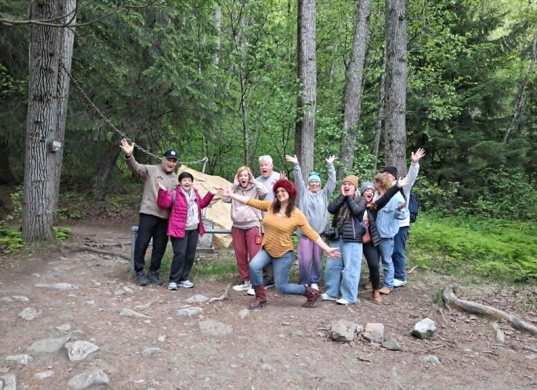 A group of people in a forested area with a dirt path. 5