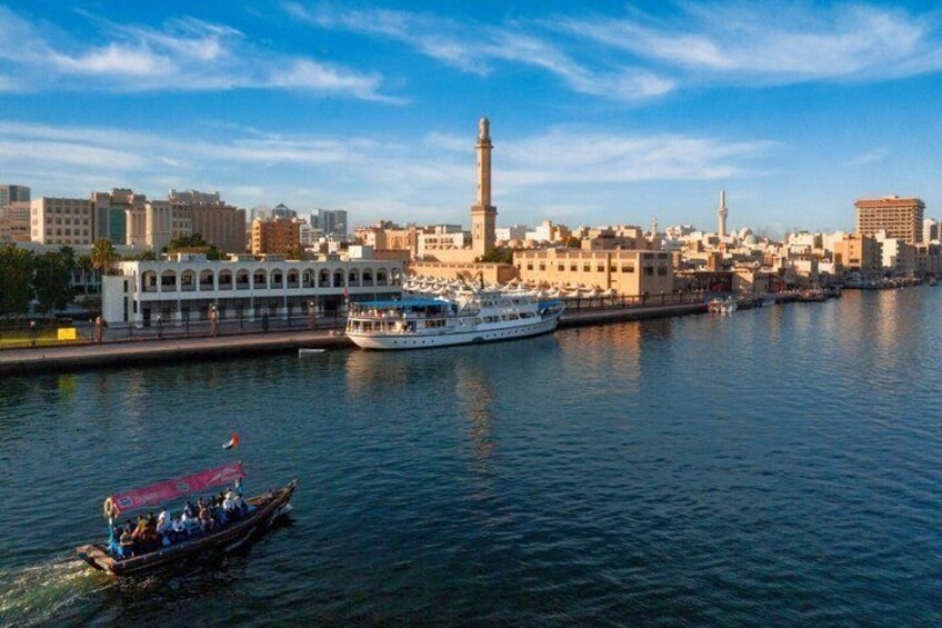 Ein Fluss mit Booten, ein markanter Turm und eine Stadtansicht mit Gebäuden. 1