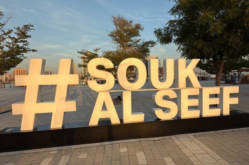 Un grande cartello esterno con il testo 'SOUK AL SEEF' e un simbolo di hashtag. 3