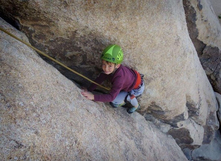 A person climbing a rock face with a rope. 3