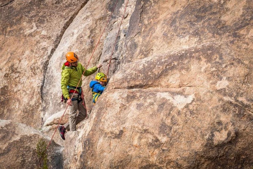Two climbers ascending a large rock face. 1