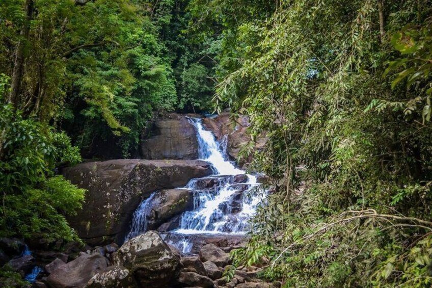 A waterfall cascading over rocks in a forested area. 3