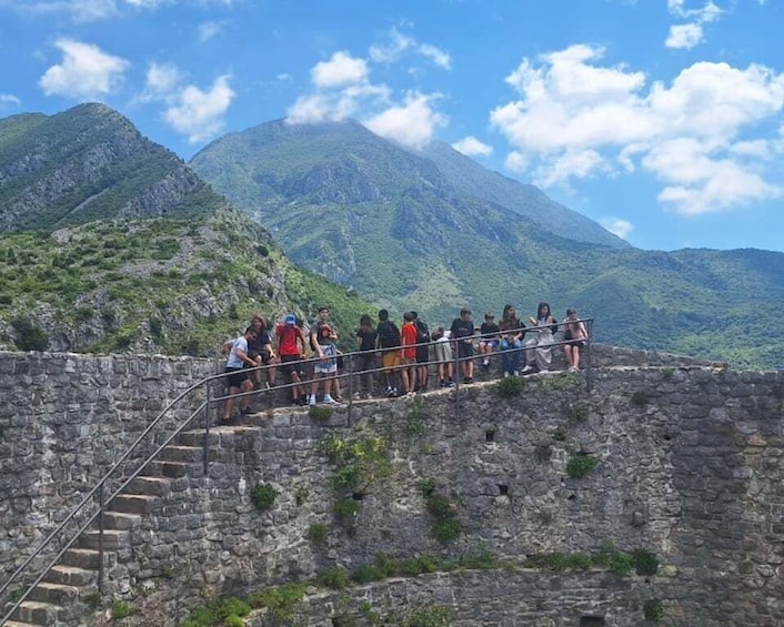 A group of people on a stone staircase overlooking a mountainous landscape. 1