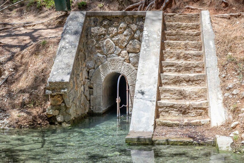 A stone staircase leading to a stone bridge over a clear water body. 3