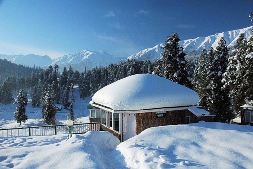 Un paisaje montañoso cubierto de nieve con un edificio de madera identificado como 'Conference Hall'. 4