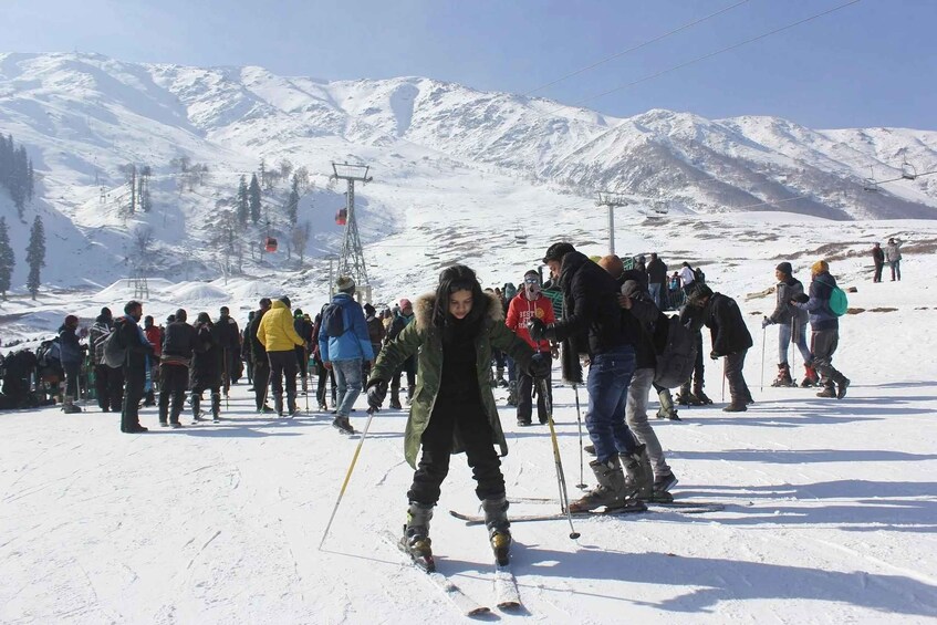 Un grupo de personas esquiando en una pendiente nevada, con montañas al fondo. 5