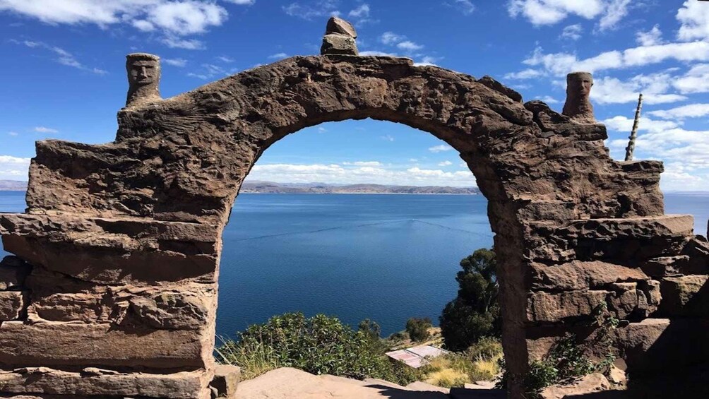 An ancient stone archway overlooking a calm sea. 1
