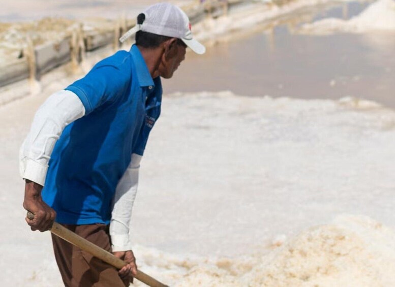 A person working with a shovel in a salt flat environment. 4