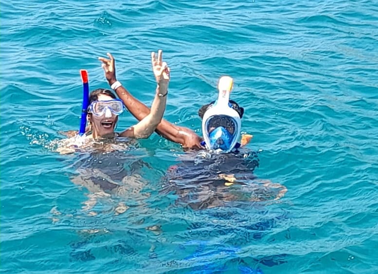 Two people snorkeling in clear blue water. 1