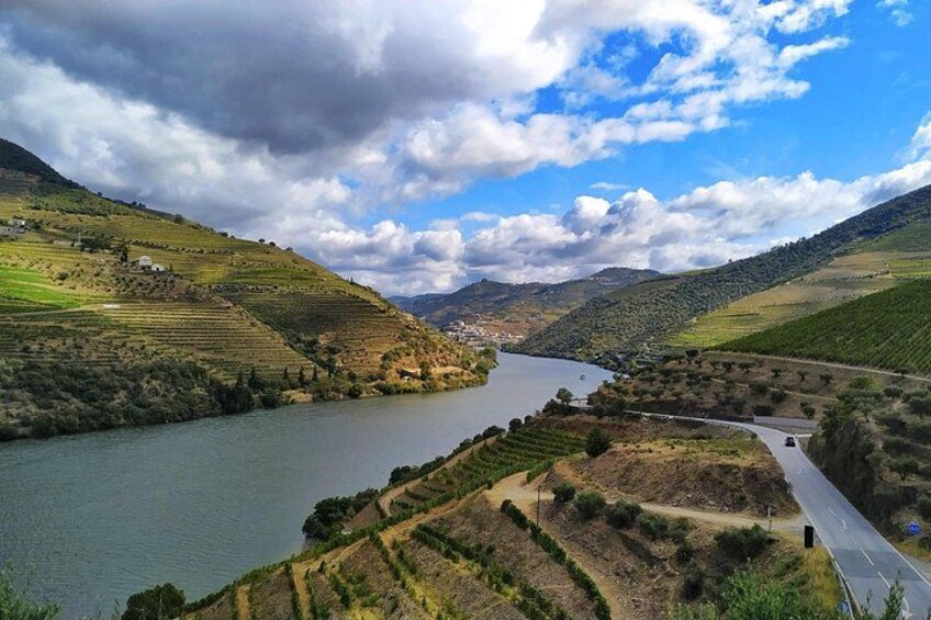 Un río serpentea a través de un paisaje montañoso con campos en terrazas y una carretera que lo acompaña. 2