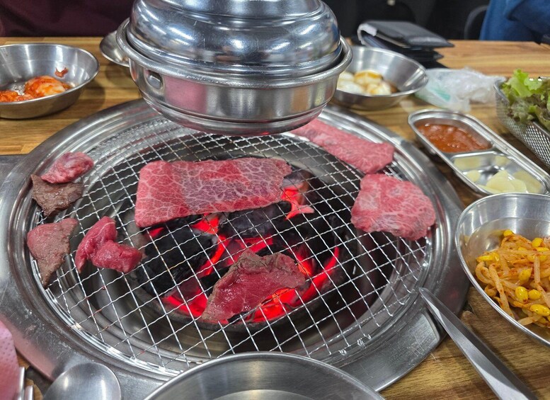 A hot plate with raw meat and various side dishes. 3