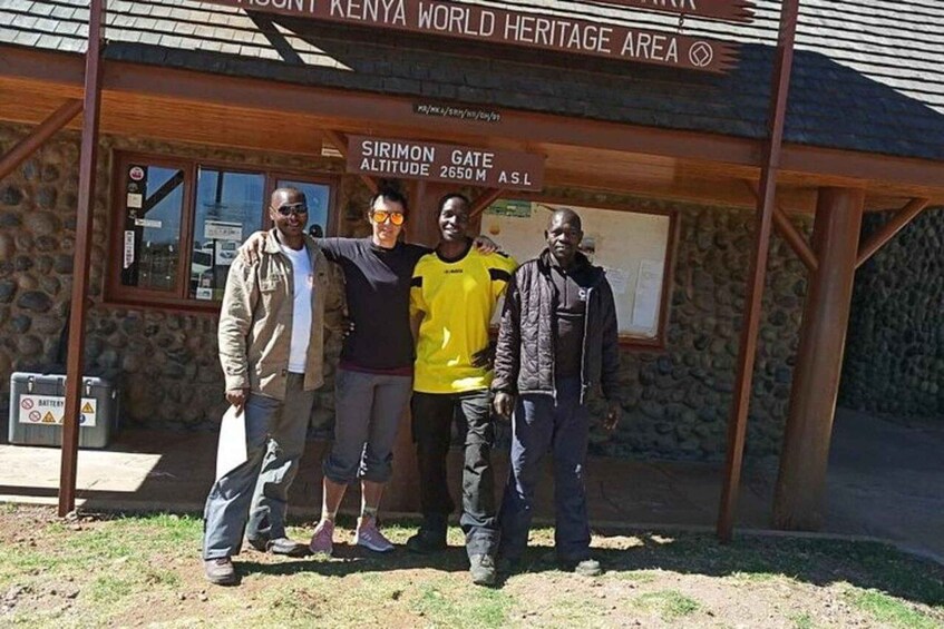A group of people standing in front of a sign that reads 'Sirimon Gate Altitude 2650 M ASL' at the Kenya World Heritage Area. 5