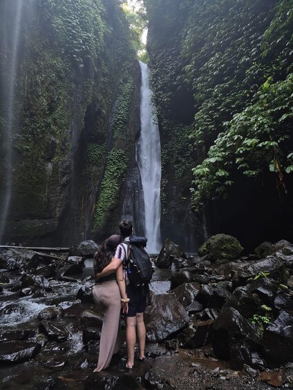 A waterfall surrounded by rocks and greenery. 4