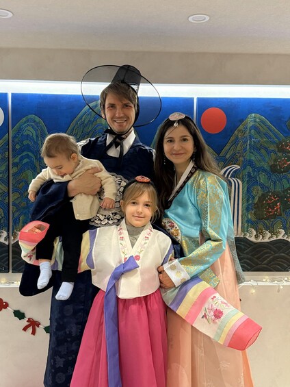 A family in traditional attire with a backdrop of Japanese art. 2