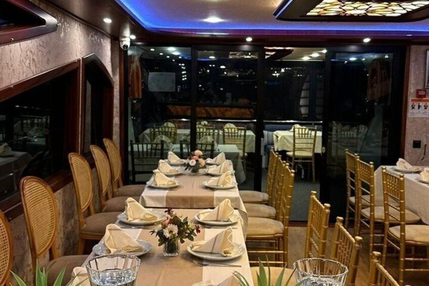 A restaurant with a long dining table set for a meal, surrounded by wicker chairs. 4