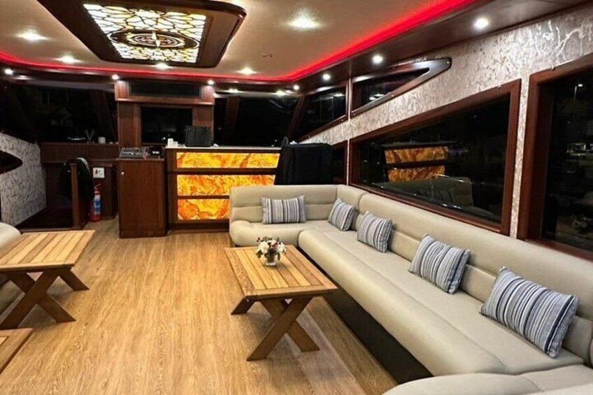 A luxurious interior with a sofa, wooden tables, and a patterned wall. 2