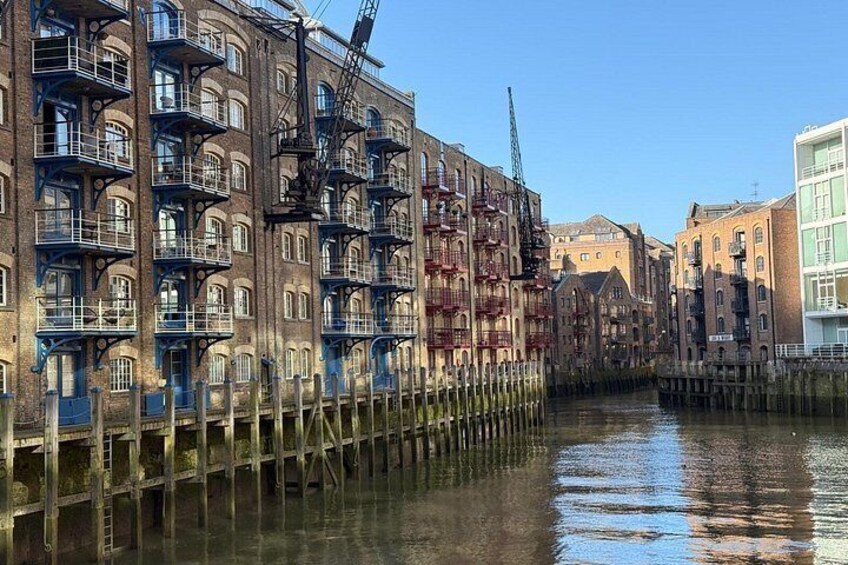 A canal with buildings on one side and a crane on the other. 4