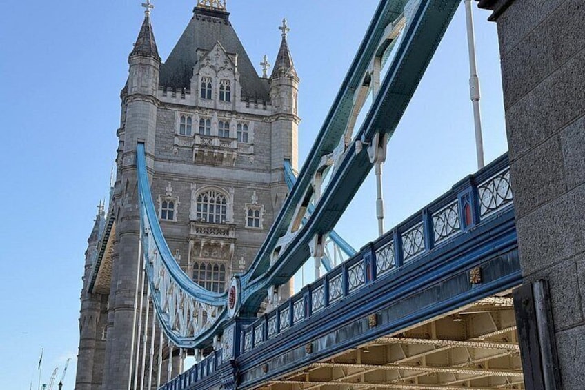 A bridge with blue railings and a historic building in the background. 5