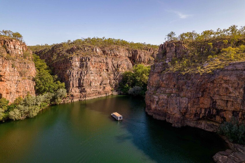 A river canyon with a boat in the water and rocky cliffs. 5