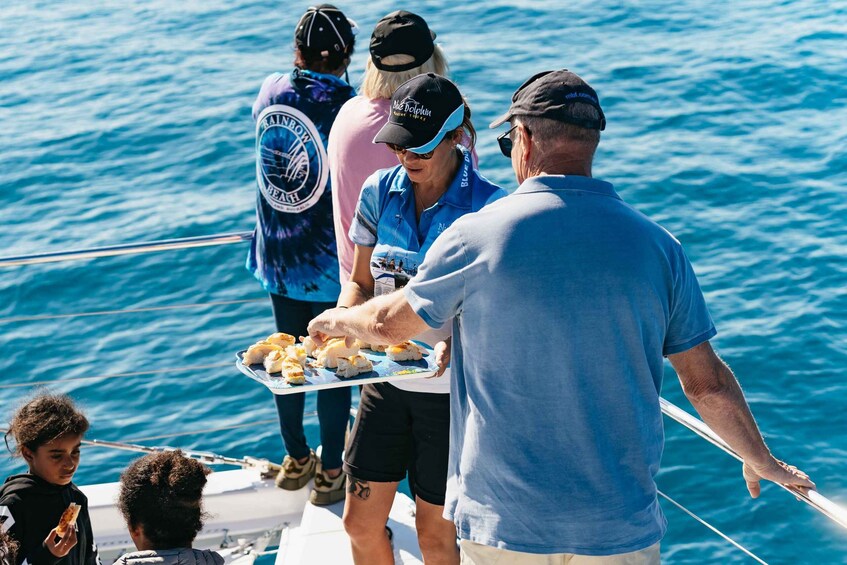 A group of people on a boat with a person serving food. 2