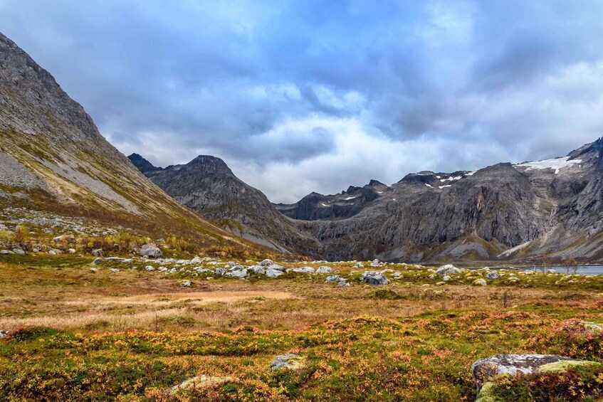 A mountainous landscape with a valley, rocky outcrops, and a body of water. 2