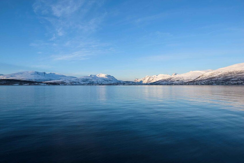 A calm lake with snow-covered mountains in the background. 4