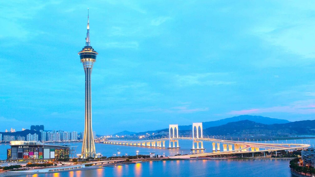 A cityscape with a prominent tower and a bridge spanning a body of water. 5