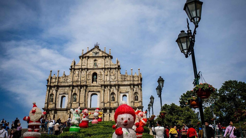 A historic cathedral with intricate architecture, surrounded by festive decorations and a crowd of people. 1