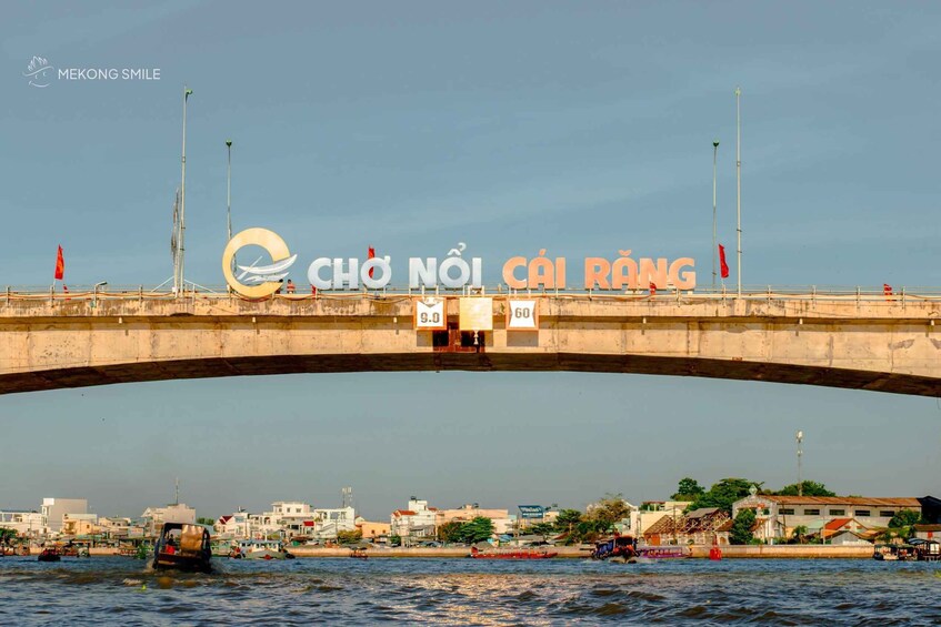 A bridge with the sign 'CHÒ NỘI CÁI RÁNG' and a boat in the water below. 5