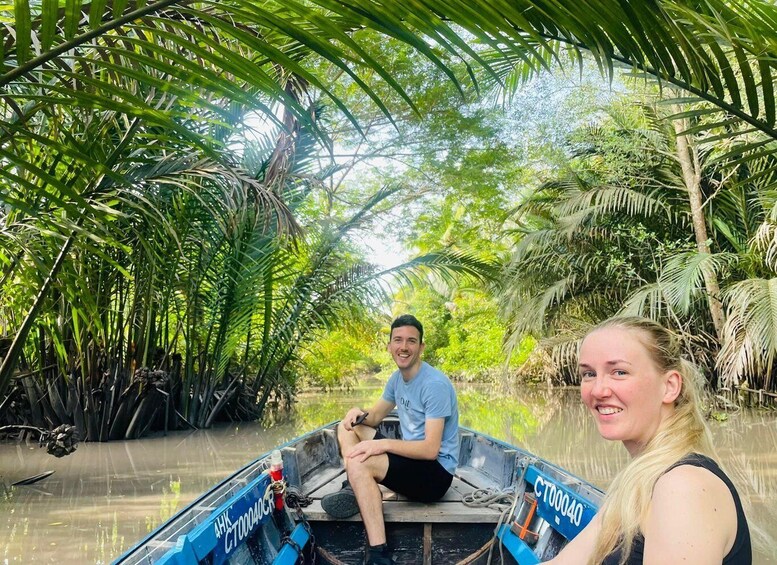 A boat navigating a waterway surrounded by dense tropical foliage. 1